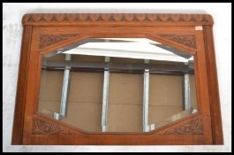 An early 20th Century carved oak over-mantle mirror carved detail to the mirror back with an