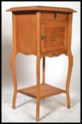 A 20th century French walnut bedside pot cupboard, single drawer over cupboard, shaped top with