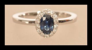 An 18ct white gold sapphire and diamond cluster ring of approx 90 points. Size M weighs 3.2 grams.