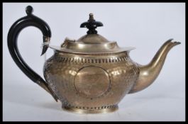 An early 20th century silver hallmarked Arts and Crafts movement teapot having a hand beaten