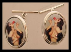 A pair of sterling silver and enamel cuff links depicting a semi nude lady. Weighs 9.6 grams.
