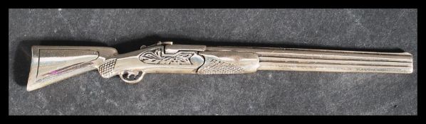 An Italian sterling silver 925 long barrelled dual shotgun with opening loading mechanism. Bearing