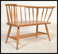 A vintage 20th century retro Ercol style dark elm and beech wood stick back telephone seat, raised