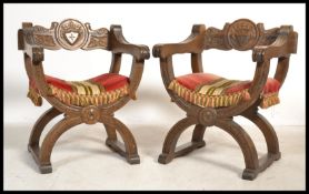 A pair of 20th century Italian carved Savonarola chairs having shaped x-frame bases with carved