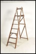 A vintage early 20th century wooden stepladder. The six step step ladder having a folding