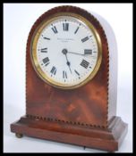 An Edwardian mahogany inlaid mantel clock of arched form retailed by Pleasance & Harper Bristol.