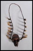 An unusual early 20th century Ifugao monkey skull trophy necklace having a braided necklace chain