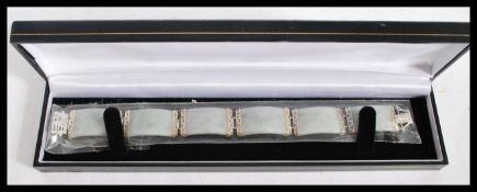 A Chinese silver and jade ladies bracelet. The jade panel spacers linked with greek key mounts and