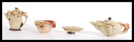 A group of Chinese hand carved soapstone to include a lidded tea pot and near matching water jug