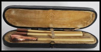 A set of 4 9ct gold hallmarked ivory cheroots set in a leather presentation case. The larger