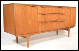 A vintage retro 20th century teak sideboard having a central bank of drawers flanked by cupboards