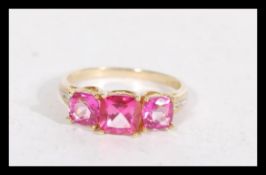 A hallmarked 9ct gold pink stone trilogy ring havi