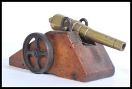 A 19th century Victorian toy cannon with brass cannon mounted on a wooden base with cast iron