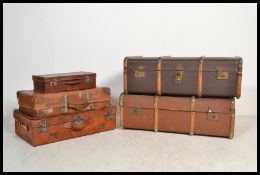 A group of vintage early 20th century luggage comprising of two wooden bound canvas steamer trunks