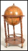 An antique style cocktail drinks cabinet in the form of a globe with hinged top section to fitted
