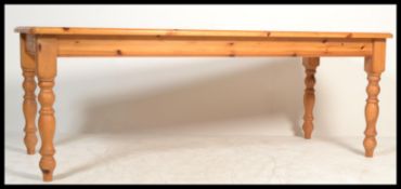 A large 20th century country pine refectory dining table having a fitted frieze with planked top