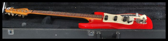 A vintage 20th century Futurama electric six string guitar having a red body complete in hard guitar