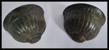 A pair of heavy cast iron wall planter pockets hav