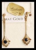 A pair of 9ct gold sapphire drop earrings having single prong set faceted sapphire stones to the