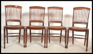 A group of four early 20th century Edwardian Industrial solid mahogany dining / boardroom chairs
