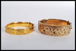 A 1/5 9ct gold metal core bangle bracelet having a half chased design along with another.