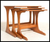 A set of three vintage 20th century Danish influence teak nest of tables in the manner of G-Plan.