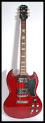 A vintage Gibson electric Epiphone six string guitar having a shaped red body with black scratch