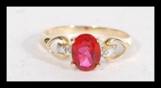 A hallmarked 9ct gold red stone and diamond accent