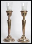 A pair of 20th century silver hallmarked candlesticks having inset glass sconces atop. Raised on
