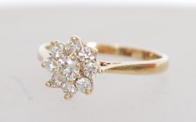 A hallmarked 9ct gold and diamond cluster ring having a central diamond with halo of smaller