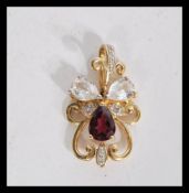 A  hallmarked 9ct gold Art Nouveau style necklace pendant set with pear cut purple and white
