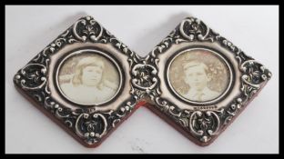 A silver hallmarked double diamond lozenge sweetheart photograph frame with rococo detailing in