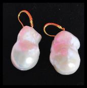 A large pair of baroque pearl drop earrings having