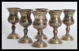 A set of six sterling silver Israeli Kiddush cup goblets raised on circular vases with embossed rose