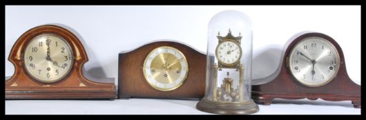 A group of four vintage clocks to include three Edwardian mantle clocks and a glass domed gilt brass