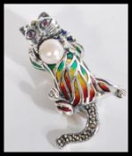 A sterling silver and plique a jour brooch in the