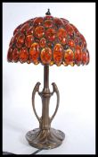 A vintage 20th century Art Nouveau style bronzed table lamp having a pressed circular base with
