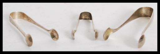 A group of three silver hallmarked sugar tongs nips dating from the 19th century to include a