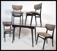 A retro 1970's teak wood dining table and chairs being raised on ebonised supports. Measures 75cms