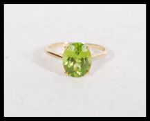 A hallmarked 9ct gold and peridot ring set with a large oval cut peridot (approx 12mm x 9mm).
