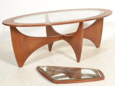 A retro teak wood atomic ' Astro ' oval coffee table by G Plan, having a drop centre glass panel,