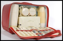 A vintage retro 20th Century Brexton picnic hamper / set, housed within a red vinyl case with two