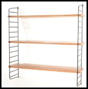 A retro mid century teak and wire work hanging shelving system in the manner of Ladderax. The teak