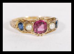 A hallmarked Victorian 12.5ct gold ring set with central garnet flanked by pearls and blue stones