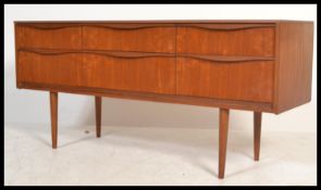A 1970's retro vintage Austinsuite teak wood six drawer sideboard with lipped handles raised on
