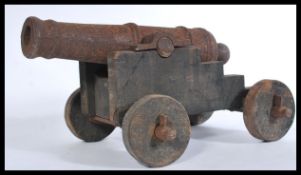 A vintage 20th century large cast iron floor cannon having wooden mounts. Measures 28 cm high, 38 cm