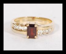 A hallmarked 9ct gold garnet and white stone ring