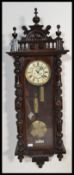 A 19th century Victorian walnut Vienna regulator wall clock by Gustav and Becker having an enamel
