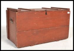 An early 20th century painted wooden trunk having cast iron drop handles. Hinged lid opening to