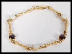 A hallmarked 9ct gold, garnet and opal set bracele